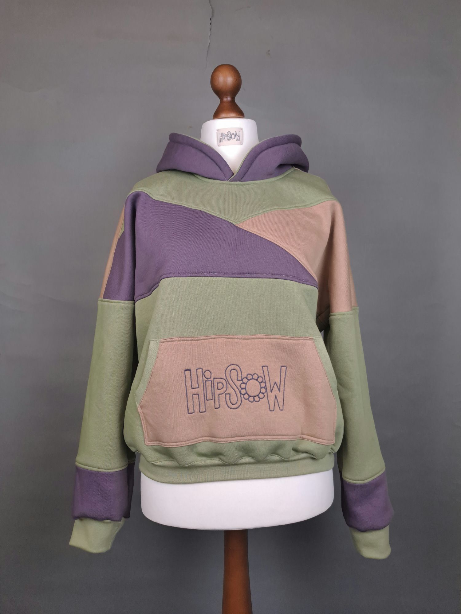 Hoodie auf Schneiderpuppe in grün, mauve, beige mit Logostickerei