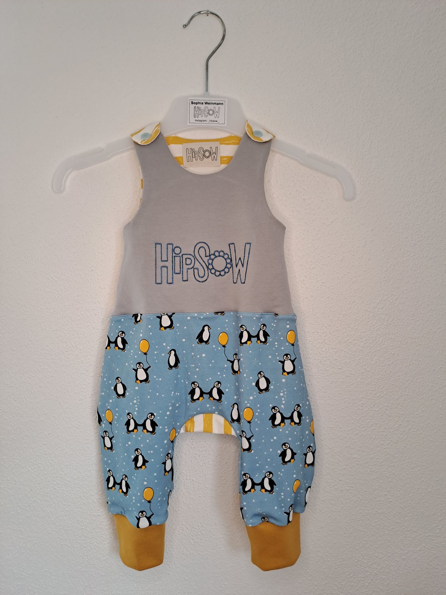 Babykleidung - ein süßer Strampler mit Pinguinen.
